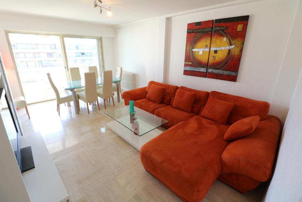 a living room with a couch and a table at 2 bedroom & studio Palais Royal 2 mins from Croisette and Carlton in Cannes