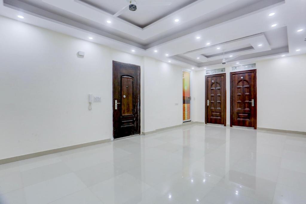 een kamer met witte muren en houten deuren bij Hotel O THE AEROSITY in New Delhi