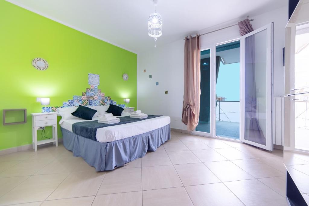 a bedroom with a large bed with a green wall at Sterlizia Rooms N in Gallipoli