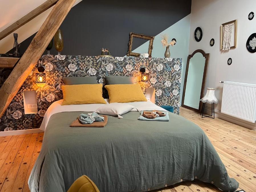 a bedroom with a large bed with two towels on it at Au Pressoir de Boisy in Pouilly-les-Nonains