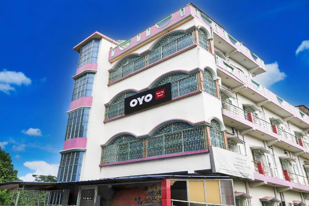 Un edificio blanco con un cartel en él. en Hotel O New Taj, en Baharampur