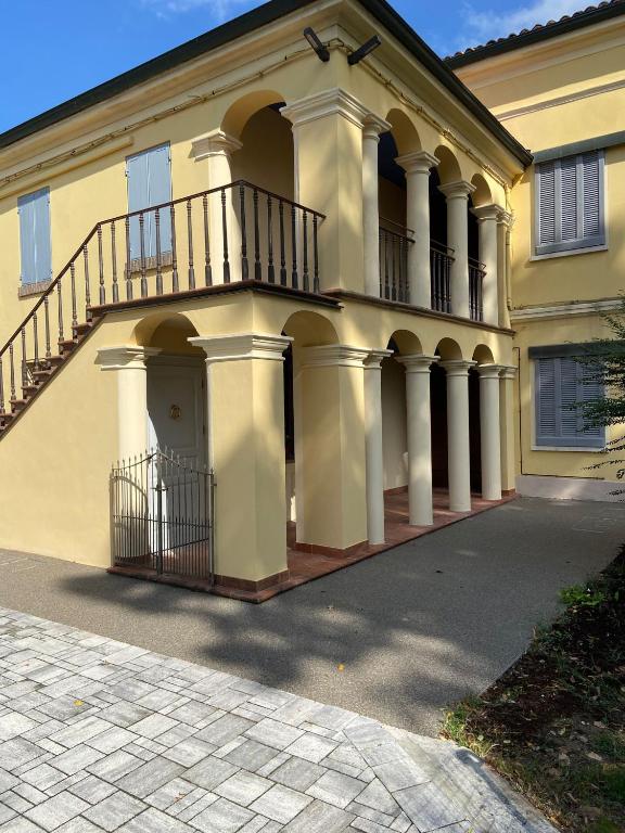 a large yellow house with a balcony on top of it at B e B Villa Livia in Rolo