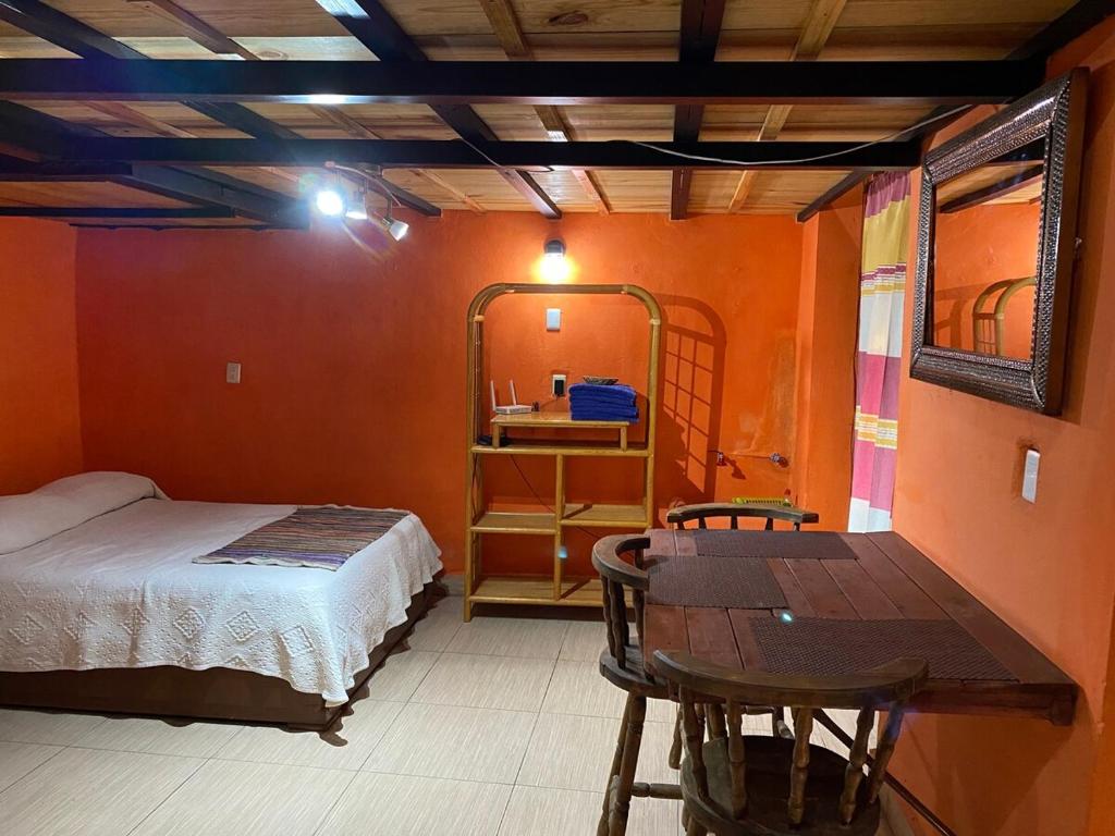 Schlafzimmer mit einem Bett und einem Tisch sowie einem Tisch und Stühlen in der Unterkunft Espacio privado muy cerca del centro in Guanajuato