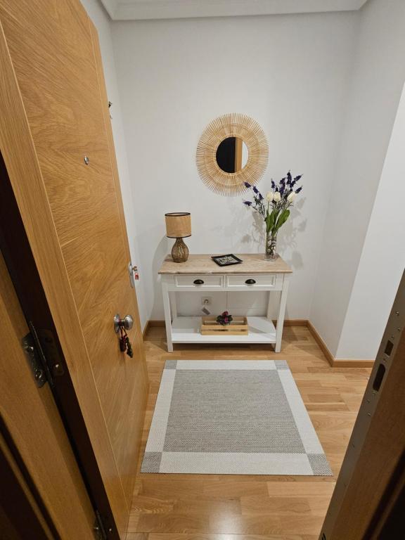 a hallway with a door and a table with a mirror at Natalia in Allariz