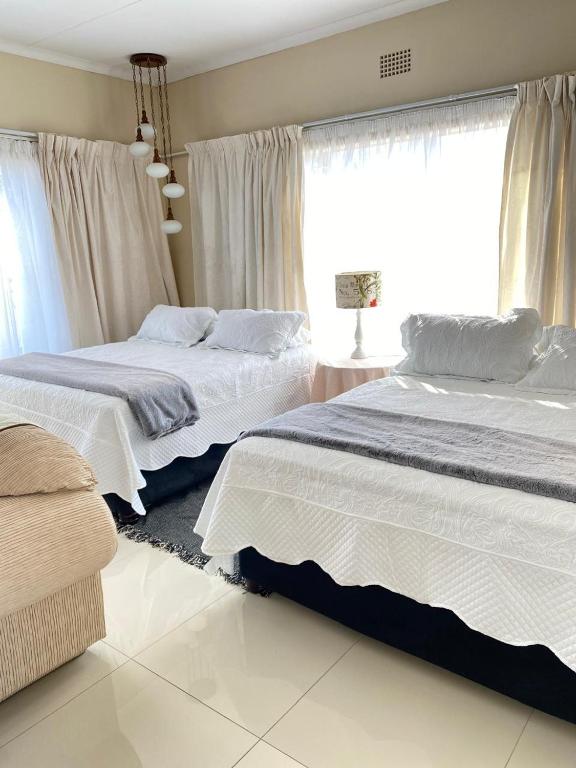 a bedroom with two beds and a window at Meadway on the parks in Benoni