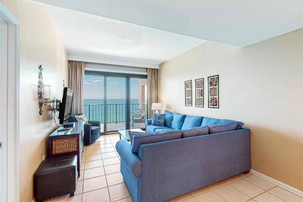 a living room with a blue couch and a television at Phoenix I 1142 in Orange Beach