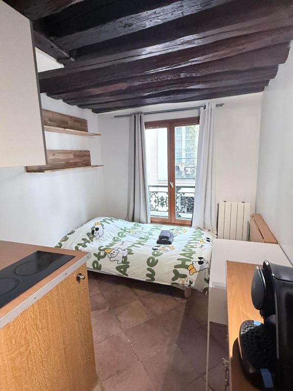 a small bedroom with a bed and a window at Elegant Studio near Pompidou Center in Paris