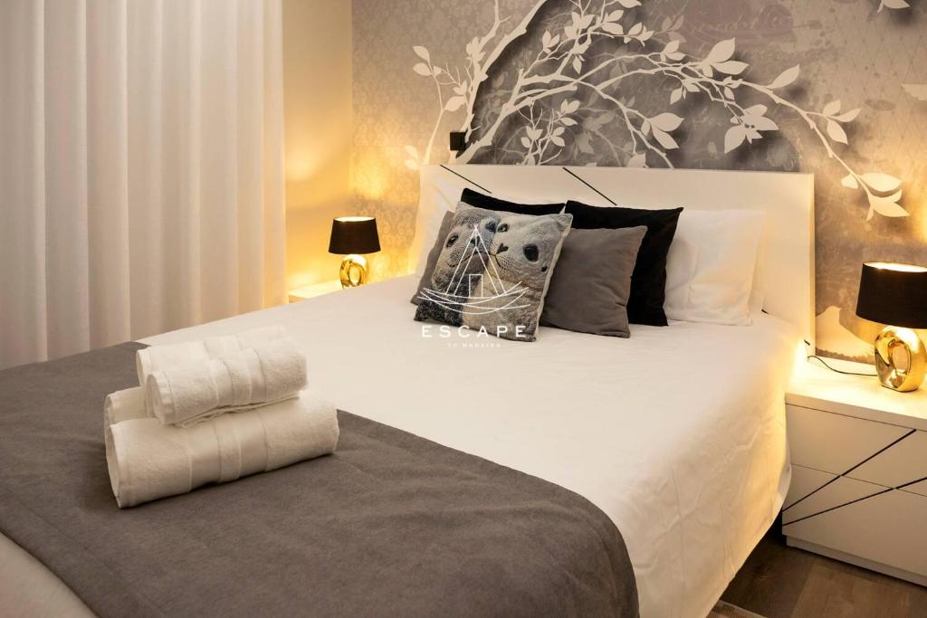 a bedroom with a large white bed with pillows at Lobos Dream Flat by Escape to Madeira in Câmara de Lobos