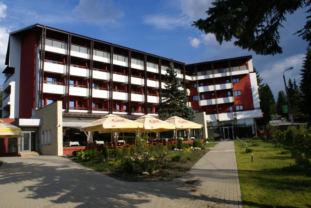 un bâtiment avec des parasols devant un bâtiment dans l'établissement Hotel Carpați, à Predeal