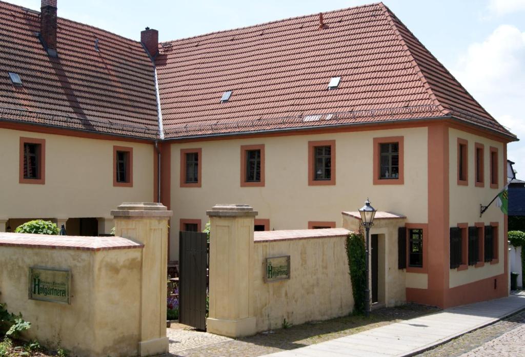 une grande maison avec un toit rouge dans l'établissement Hofgärtnerei, à Altenburg