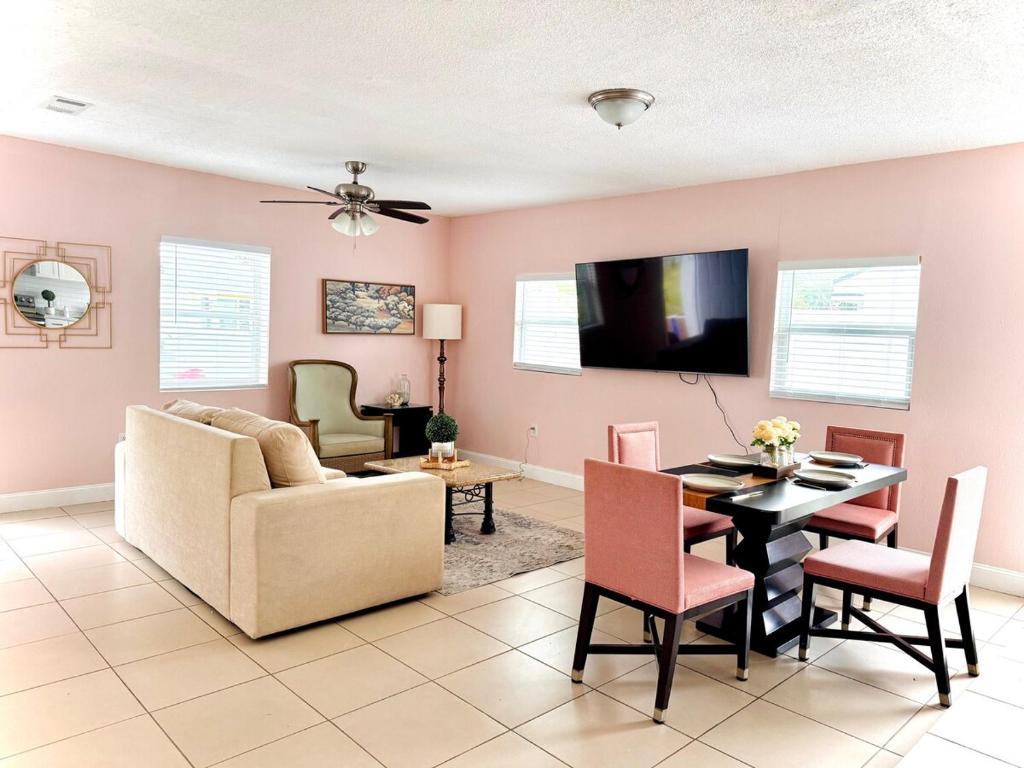 a living room with a couch and a dining room table at Poolside Suite APT 15 min from ThemeParks & MCO in Kissimmee