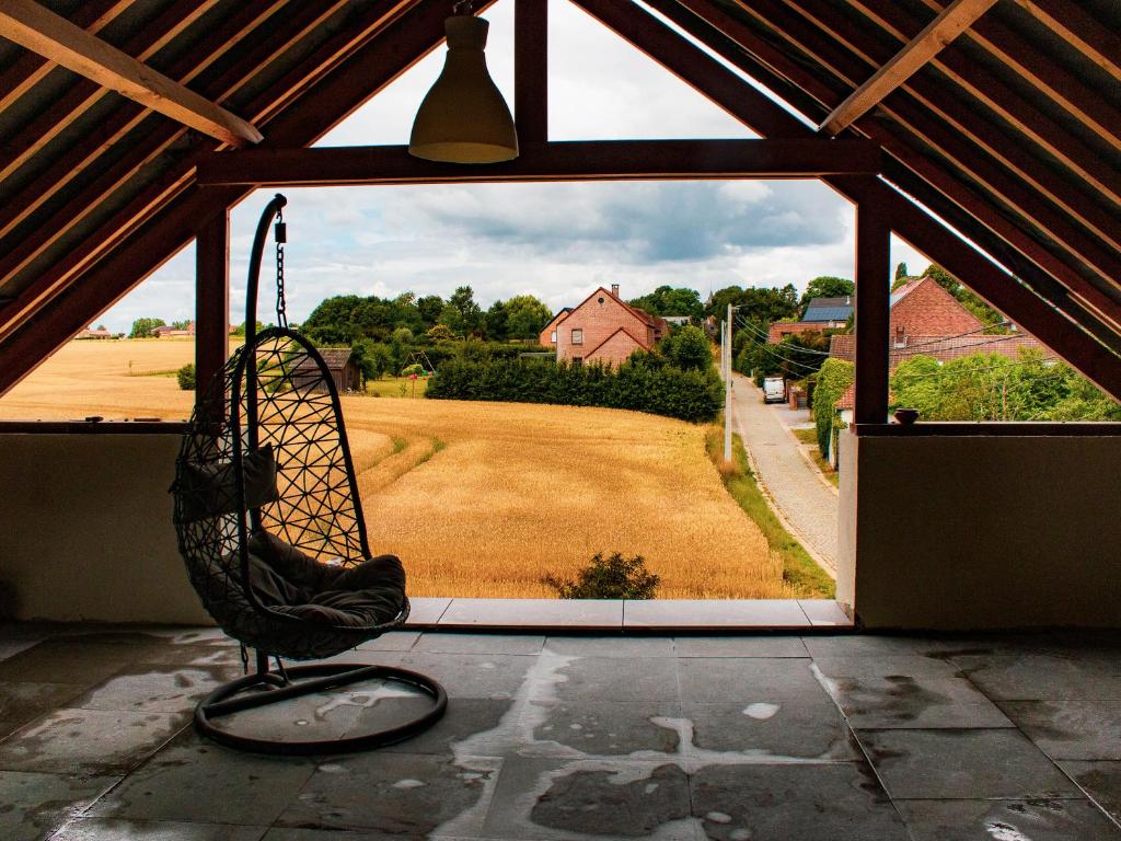 a swing in a room with a large window at Au Vent des Blés in Incourt