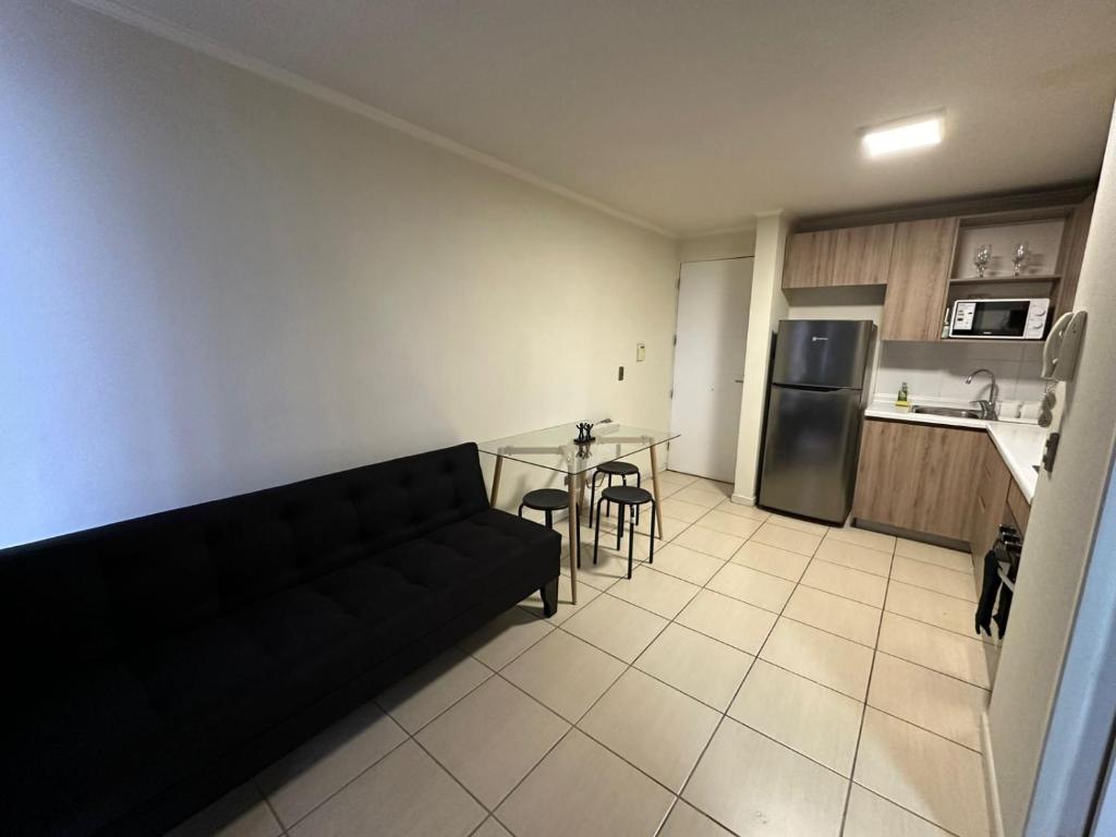 a living room with a black couch and a table at Depasfs in Santiago