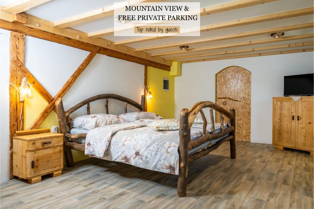 1 dormitorio con cama de madera y TV en Sobe na skednju, en Bohinjska Bistrica