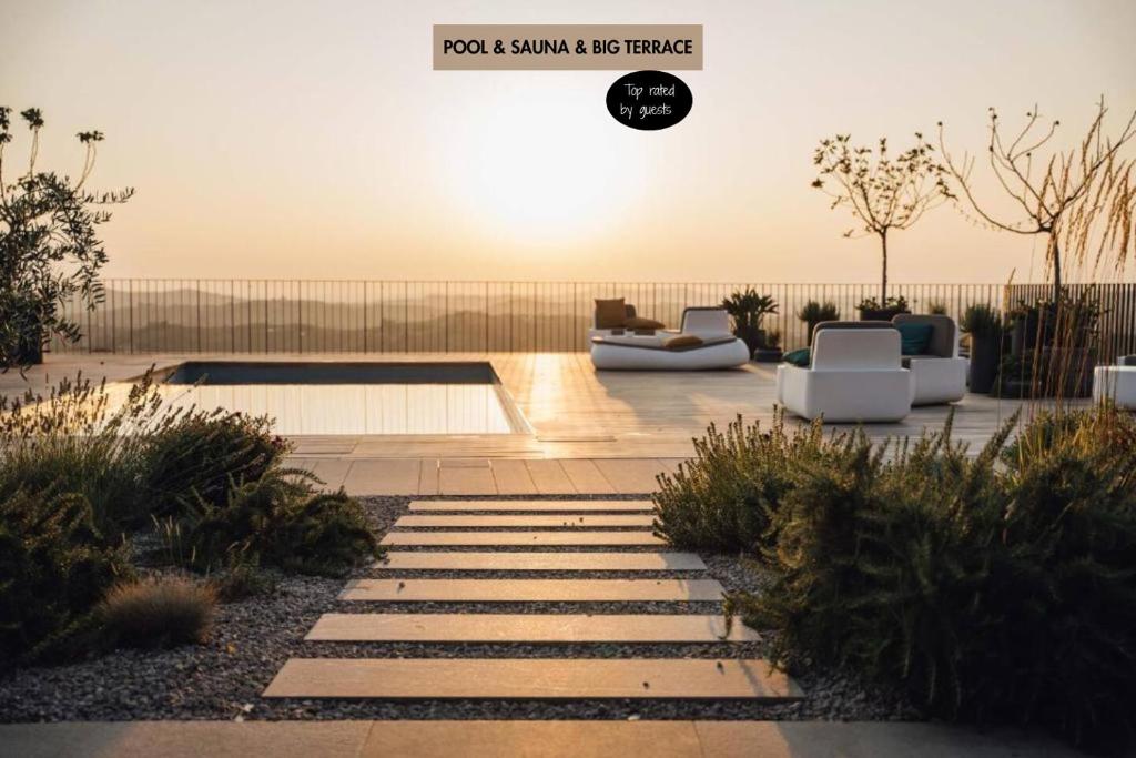 a garden with chairs and a patio with the sun setting at VILLA ZEROU in Kojsko