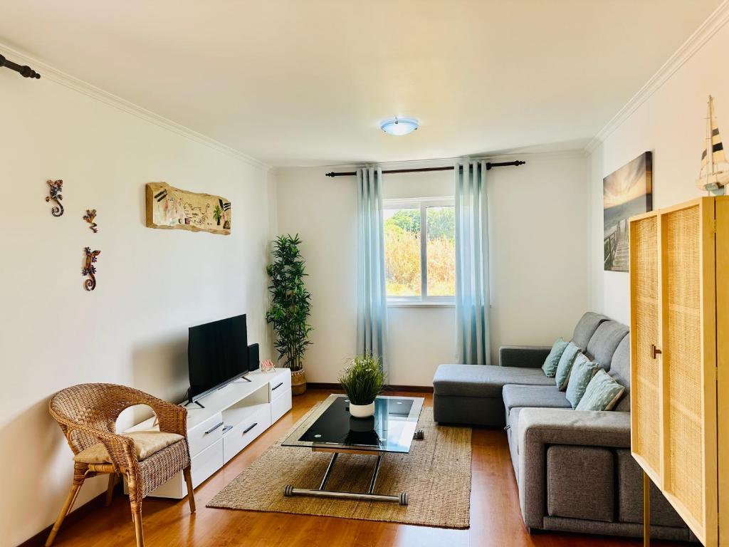 a living room with a couch and a tv at Ocean Gardens in Caniço