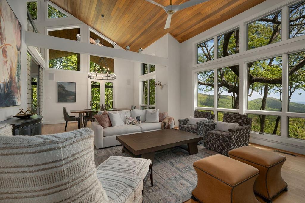 a living room with a lot of windows at Heaven and Earth - Luxury Accomodations, Breathtaking Mountain Views, Game Rooms + More! in Jasper