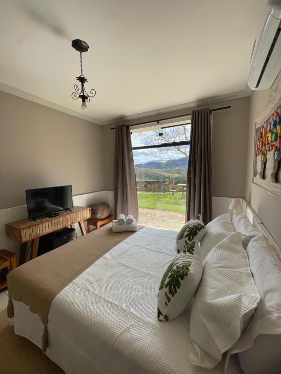 a bedroom with a large bed and a window at Pousada Varandinha in Tiradentes