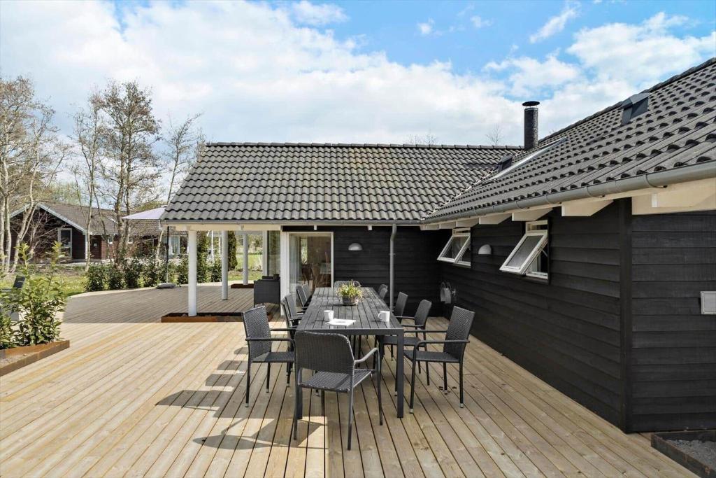 a patio with a table and chairs on a wooden deck at M184-Vaeggerlose-Kaninstien-41 in Bøtø By