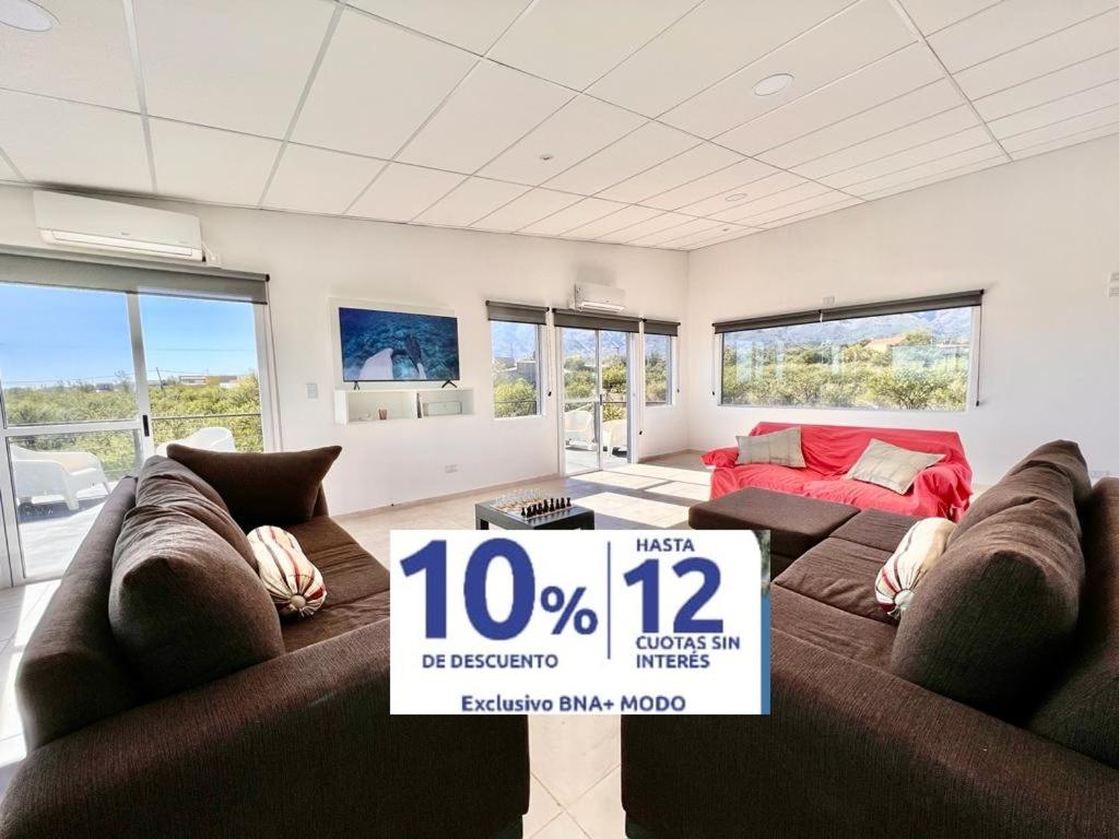 Una sala de estar con dos sofás marrones y un cartel de venta. en Anubis, en Merlo