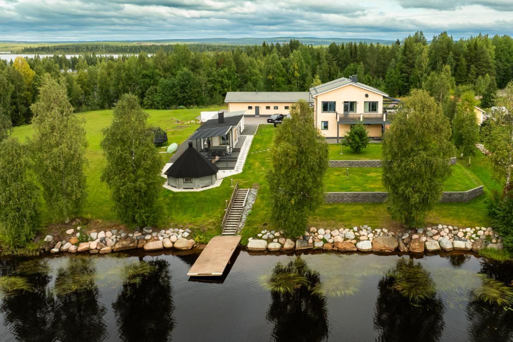 - une vue aérienne sur une maison à côté d'un lac dans l'établissement Riverside Luxury Retreat By BookLapland, à Rovaniemi