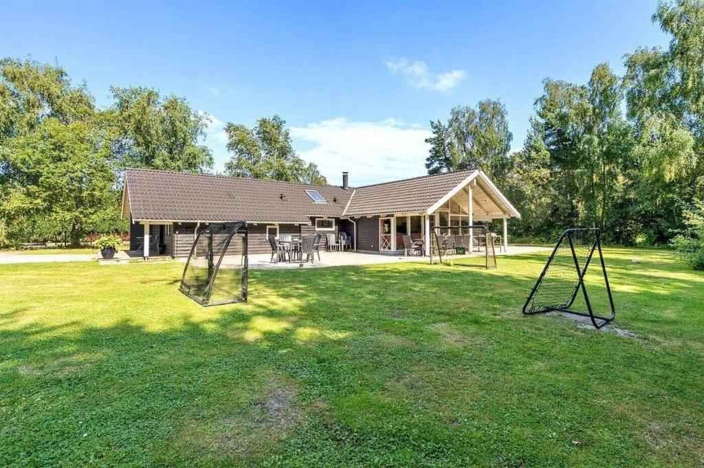 un cortile con due altalene di fronte a una casa di M324-Vaeggerlose-Baeverstien-10 a Bøtø By