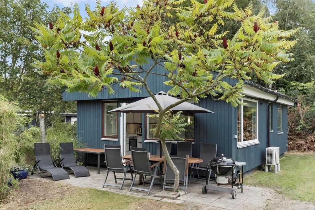 a tiny house with a table and chairs and a grill at M225-Idestrup-Jasminvej-22 in Bøtø By