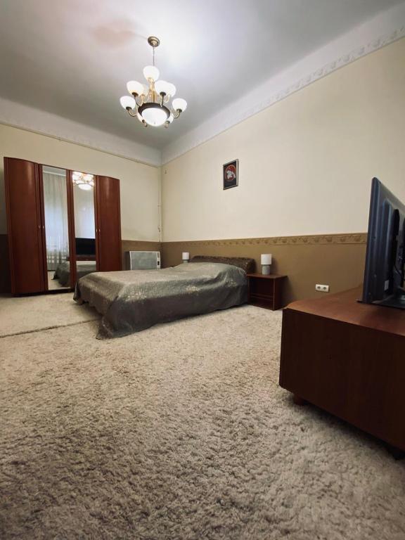 a large bedroom with a bed and a chandelier at Апартаменти в центрі in Chernivtsi