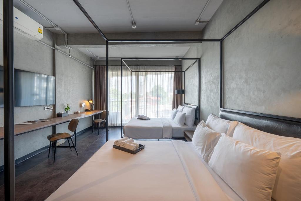 a hotel room with a bed and a desk at Palette The Ex Capital Hotel Bangkok in Bangkok