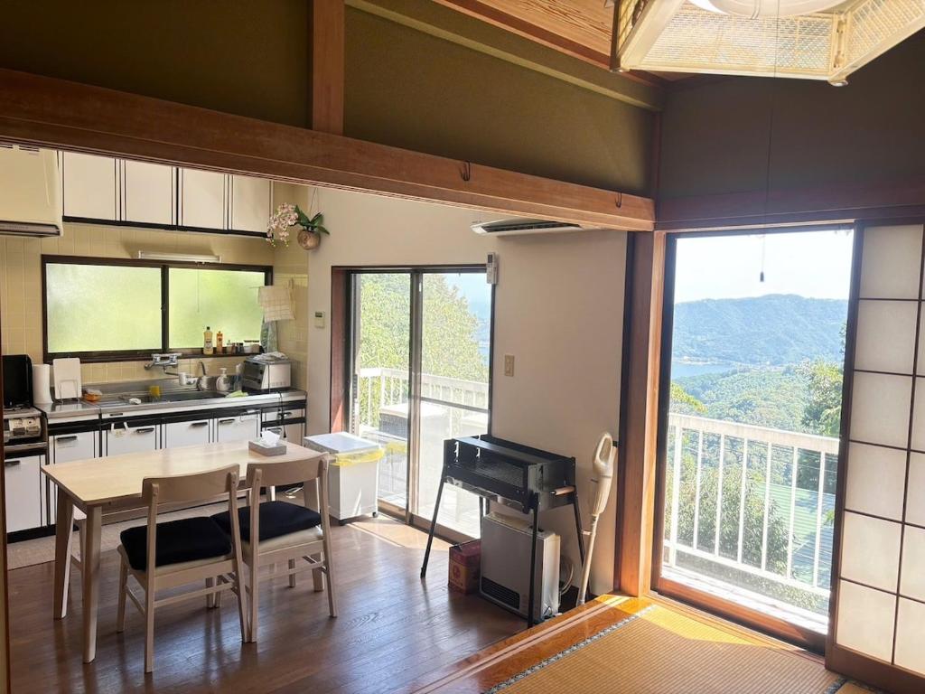 a kitchen with a table and a view of a balcony at Atami Umine Villa in Atami