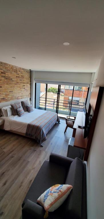 a bedroom with a large bed and a couch at PARDO Boutique in Bogotá