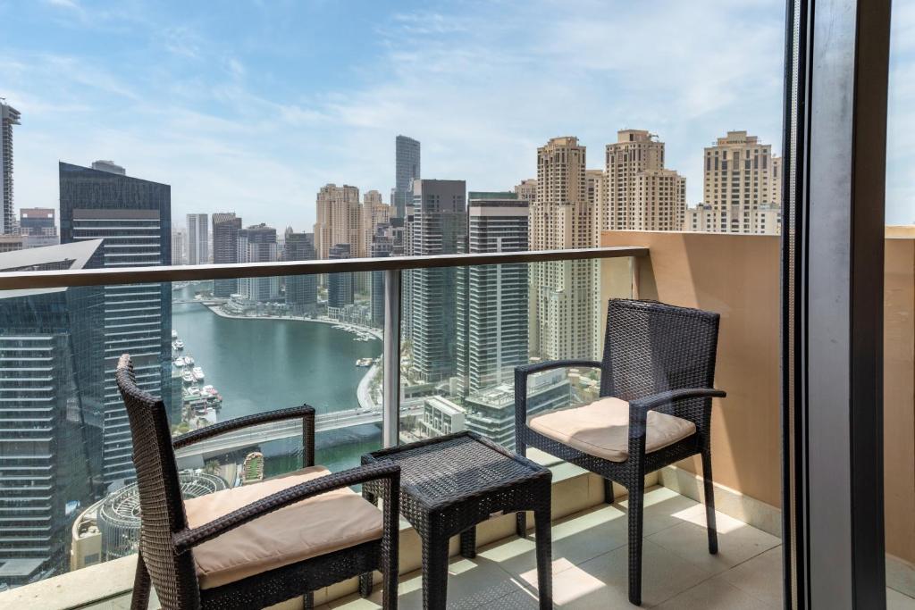 a balcony with two chairs and a view of the city at Seaview & Marina View Studio in Dubai