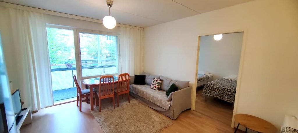 a living room with a table and a couch at Kotikaksio Deodar in Lahti