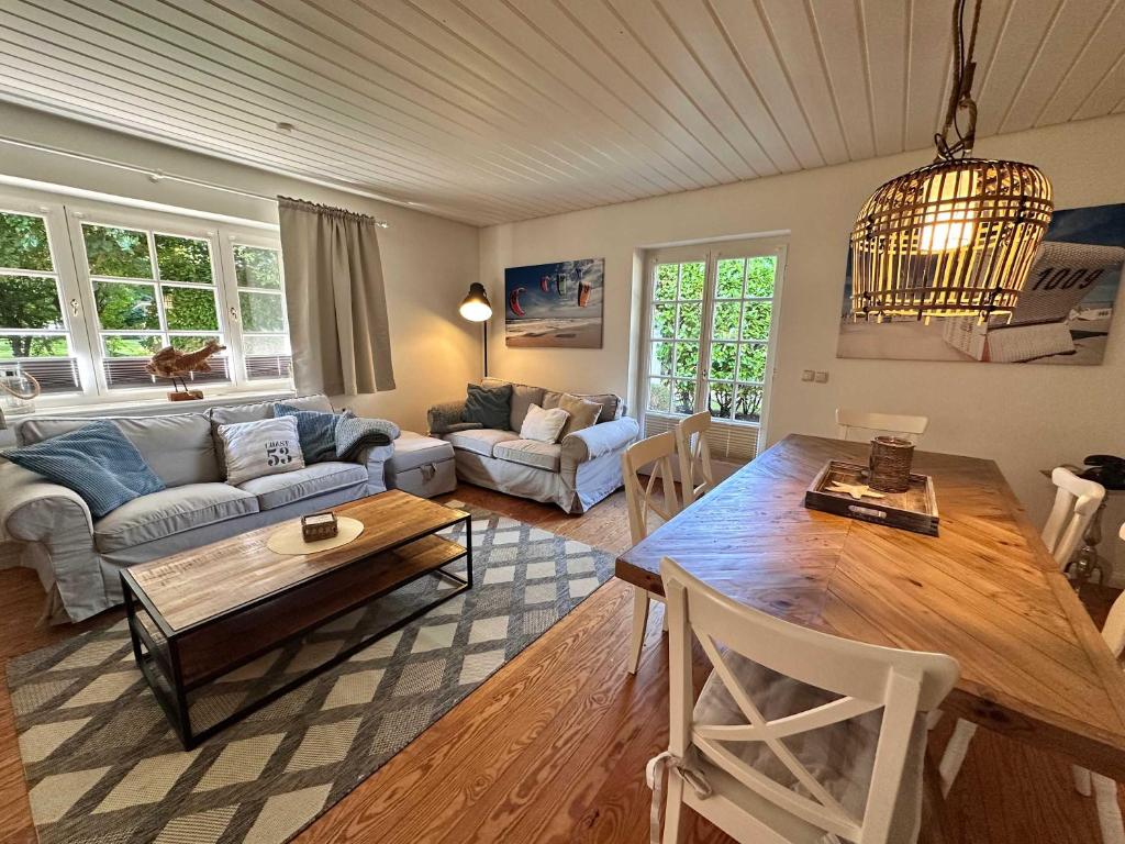 a living room with a table and a couch at 3 Zimmer Wohnung in Reetdachanwesen Hus op de Duen in Sankt Peter-Ording