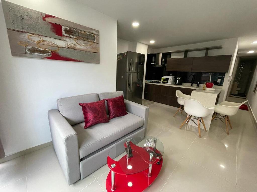 sala de estar con sofá y mesa roja en Apartamento Ideal y Tranquilo, en Sabaneta