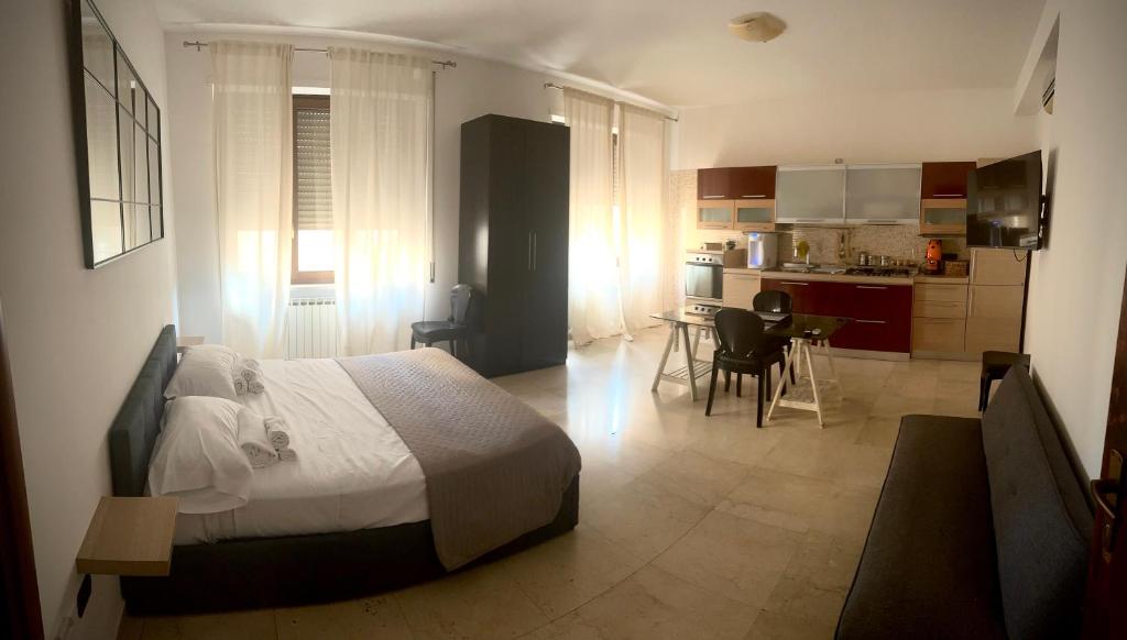 Un dormitorio con una cama grande y una cocina. en B&B 31 mt dal Duomo, en Benevento