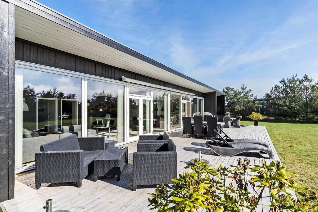 a deck with chairs and tables on a house at M167-Vaeggerlose-Savavej-31 in Marielyst