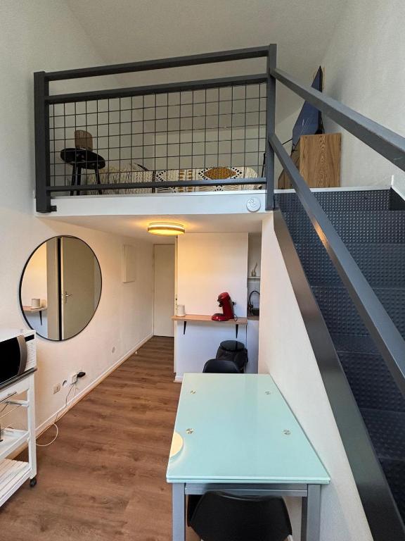 a loft apartment with a staircase and a table at Le Cocon des Géants in Toulouse
