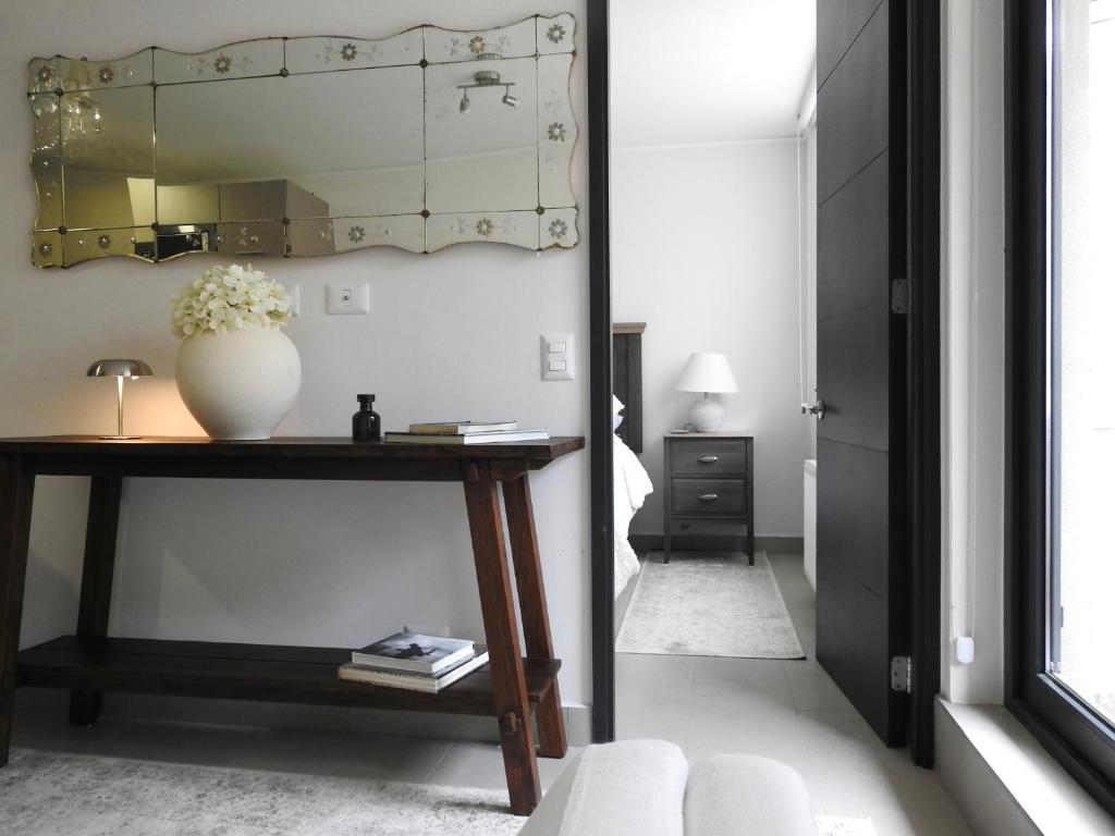 Una sala de estar con una mesa y un espejo. en Cozy and relax Apartment, en Puerto Natales