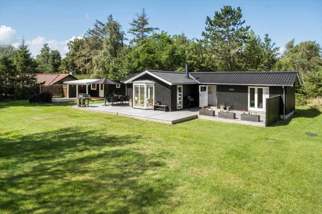 a black house in a yard with a green lawn at K20092-Gorlev-Skovhusvej-27 in Gørlev