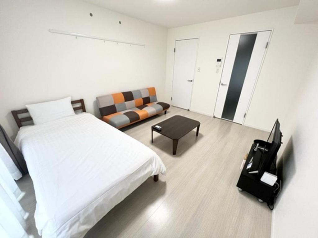 a white room with a bed and a couch at M,ULTRA - Vacation STAY 16696 in Kagoshima