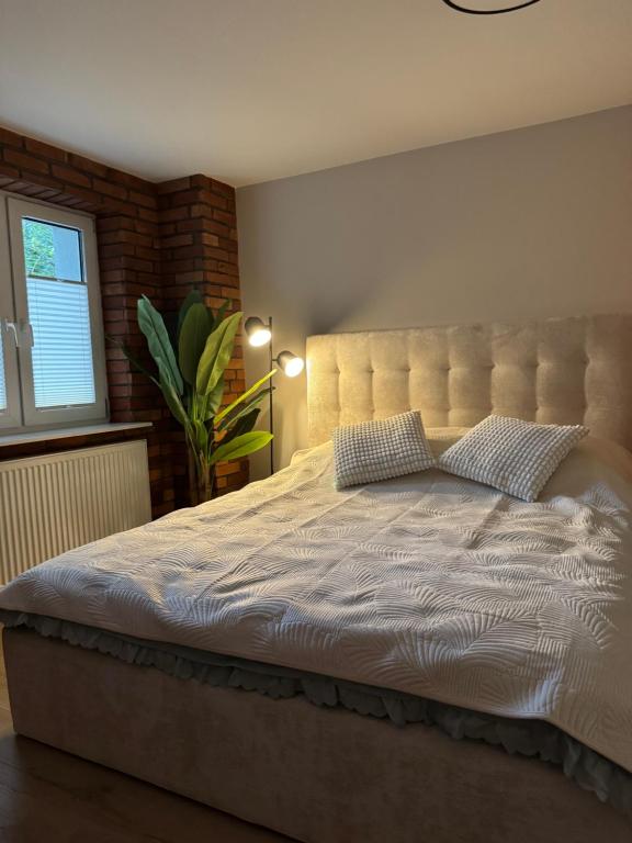 a bedroom with a large bed with pillows on it at Apartamenty przy parku in Elblag