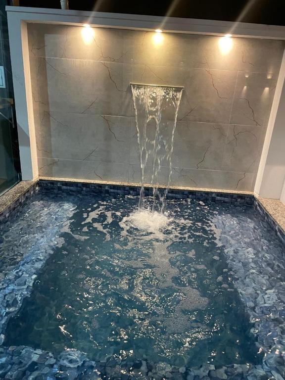 a pool of water with a fountain at Casa Solar Beach in Vilhena