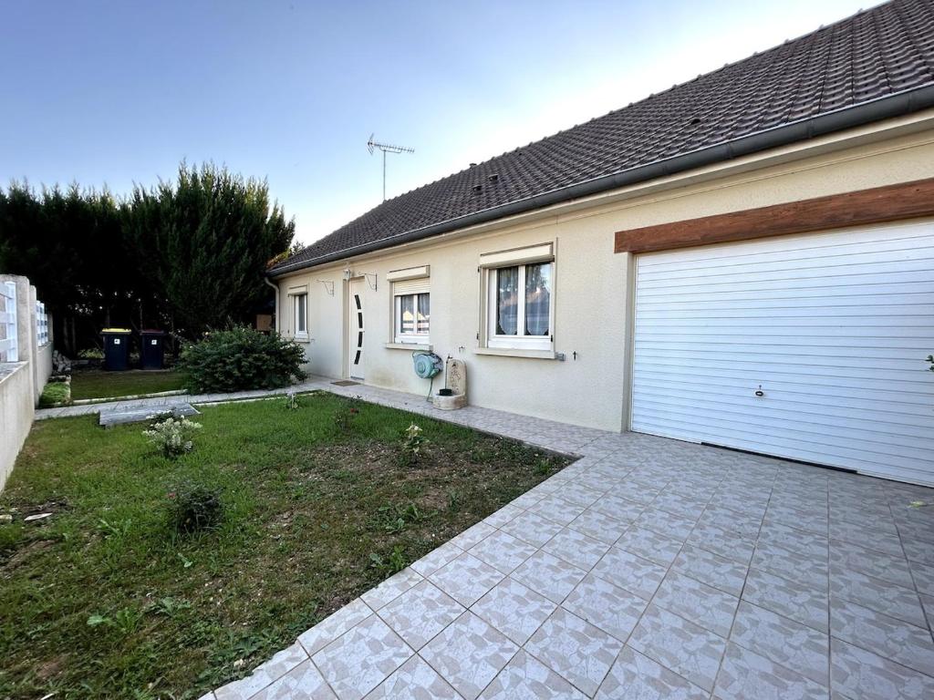 Verneuil-lʼÉtangにあるJolie et charmante maison accessible depuis Parisのガレージドアと私道のある家