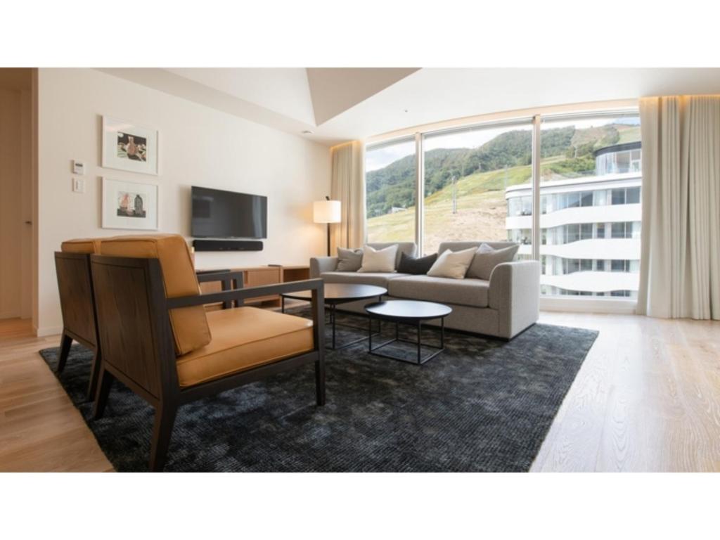 a living room with a couch and a table at Skye Niseko - Vacation STAY 70618v in Niseko