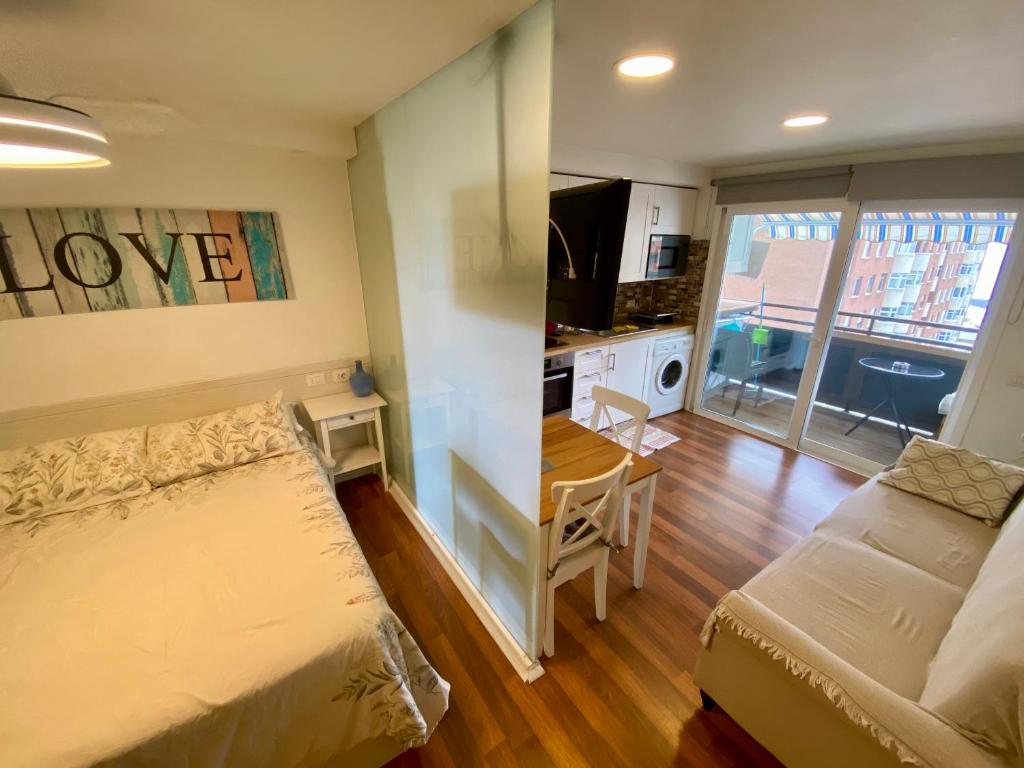 a bedroom with a bed and a desk and a kitchen at LOFT vistas playa jardin in Puerto de la Cruz