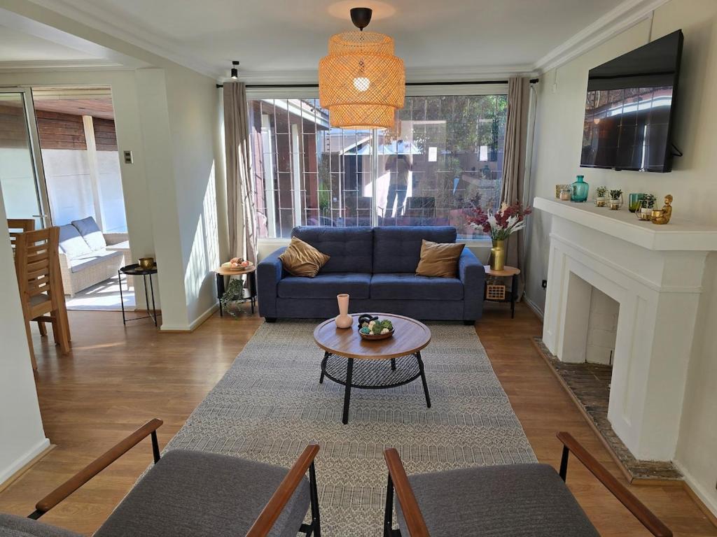 a living room with a blue couch and a table at Spacious and beautiful house in Las Condes in Santiago
