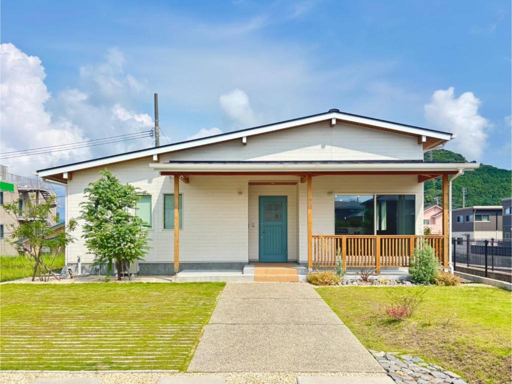 ein kleines weißes Haus mit blauer Tür in der Unterkunft Nagasaki - House - Vacation STAY 19938 in Nagasaki
