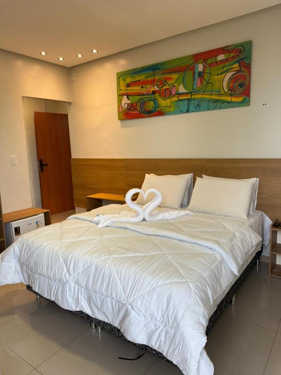 a large bed with a white swan on it at Hotel Mapuera in Oriximiná