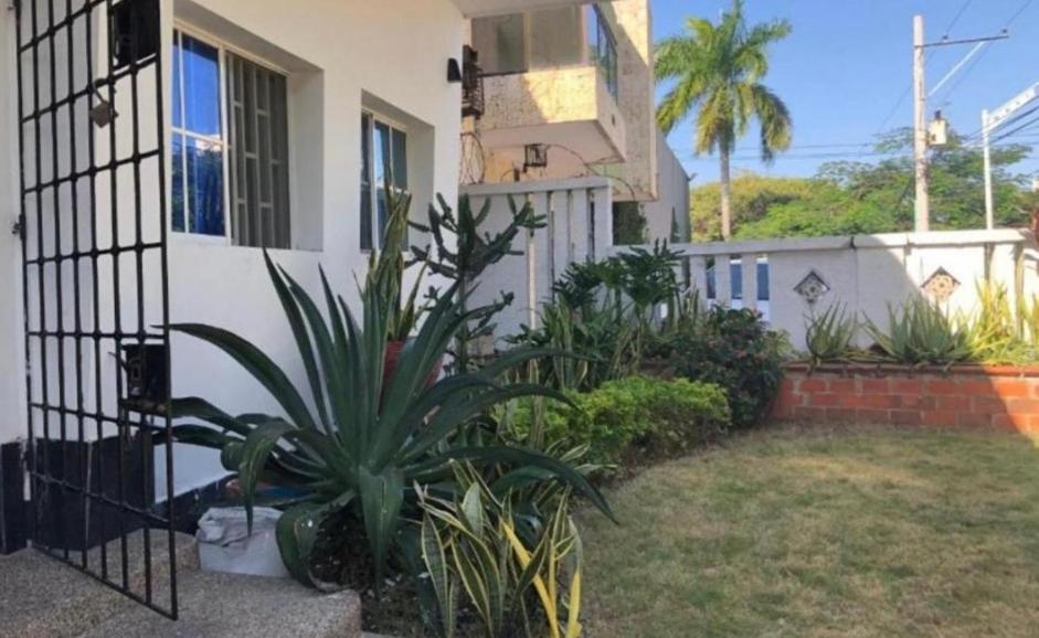 a house with a gate and a plant in the yard at Alto prado 75 house in Barranquilla
